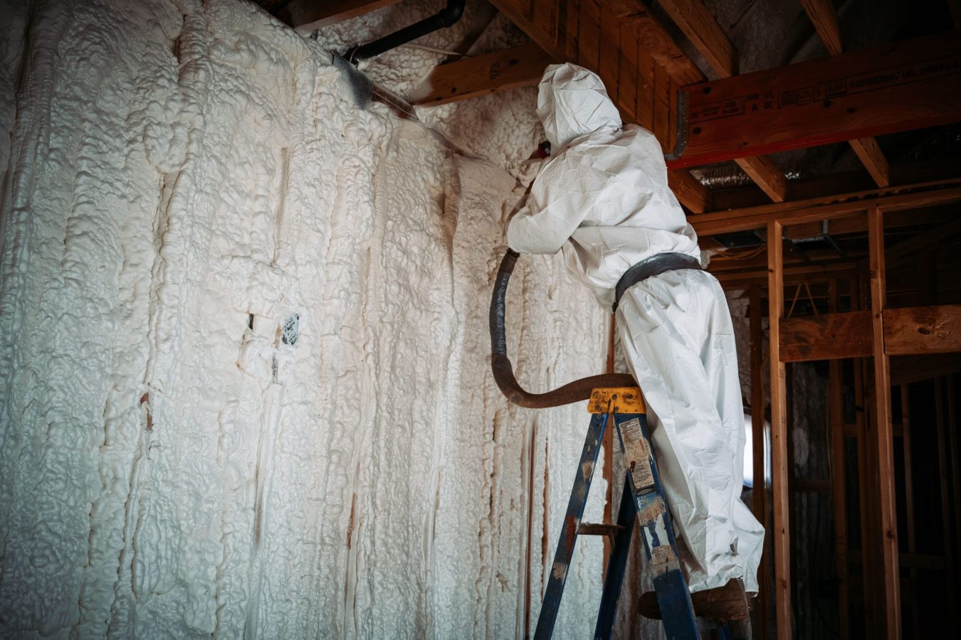 Worker doing spray foam insulation on the walls A worker doing spray foam insulation on the walls